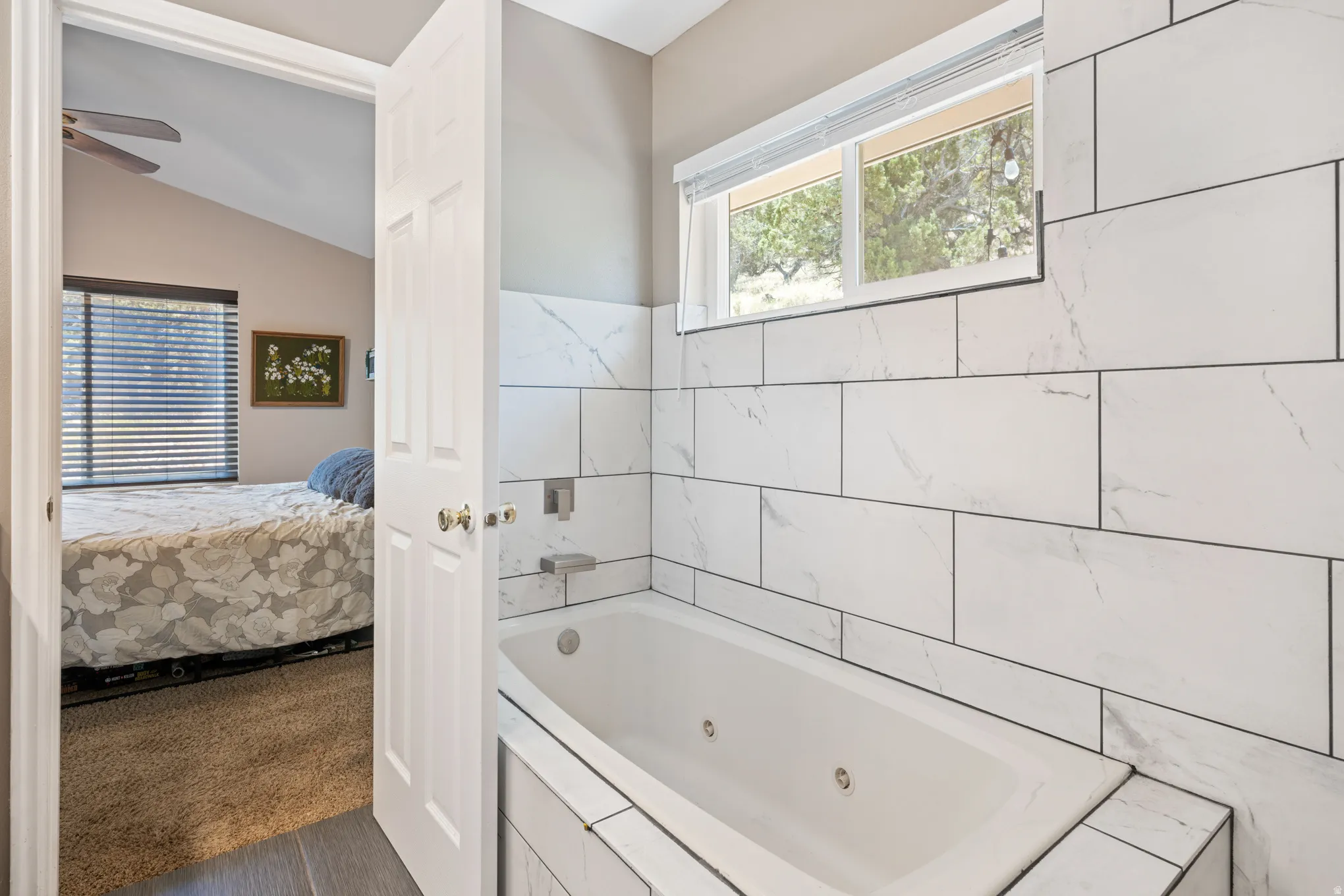 Soaking tub with white subway tile surround, featuring integrated wall-mounted fixtures