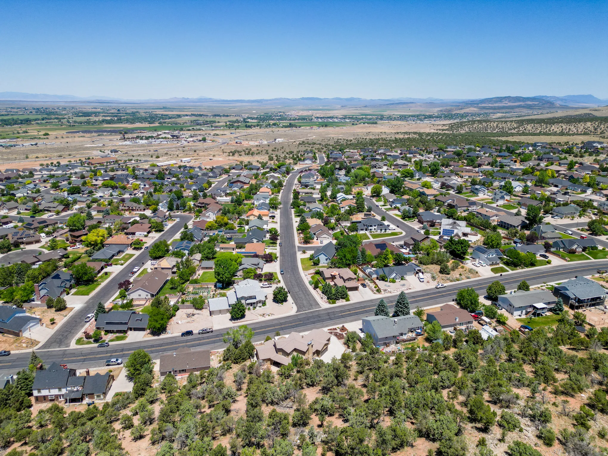Expansive residential landscape featuring numerous single-family homes with diverse architectural styles, paved streets, and mature trees