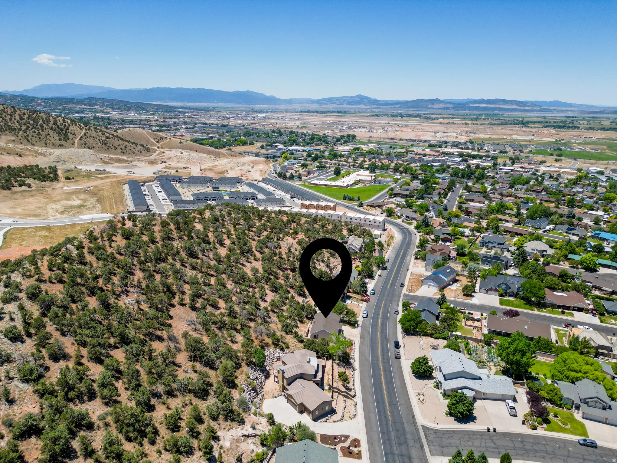 Elevated property featuring a natural, treed hillside setting, overlooking a developed residential area