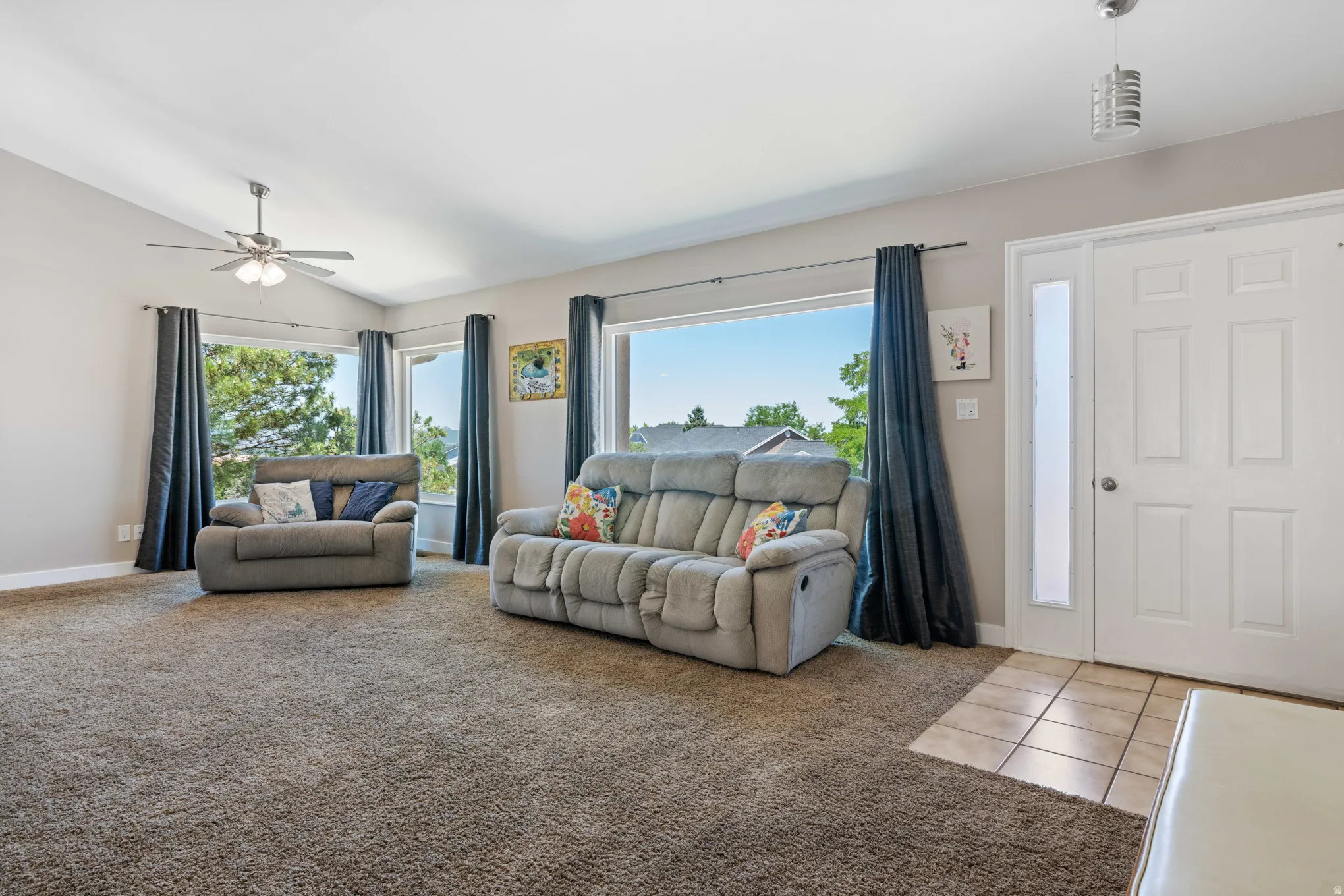 Spacious living area featuring vaulted ceilings and multiple windows providing abundant natural light