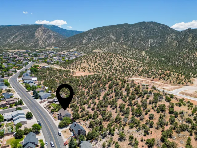 Aerial perspective showcasing a property situated along a paved road with surrounding residential structures