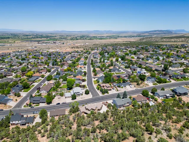 Expansive residential landscape featuring numerous single-family homes with diverse architectural styles, paved streets, and mature trees