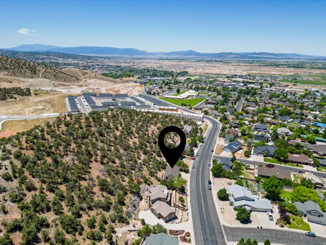 Elevated property featuring a natural, treed hillside setting, overlooking a developed residential area