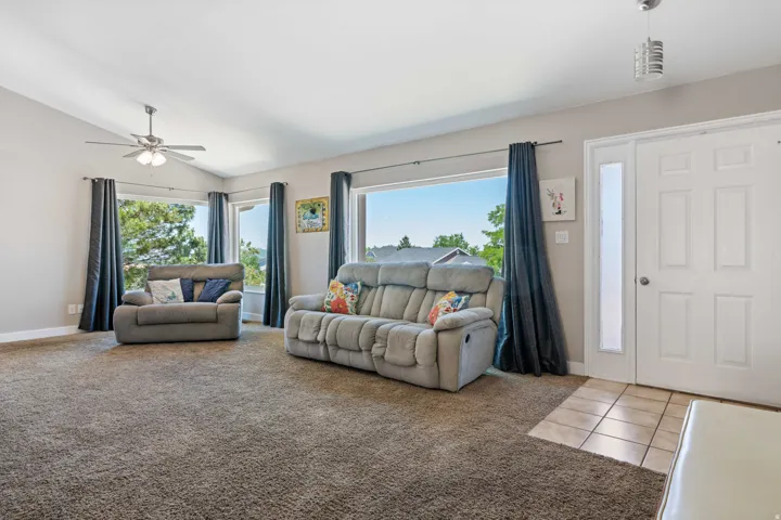 Spacious living area featuring vaulted ceilings and multiple windows providing abundant natural light