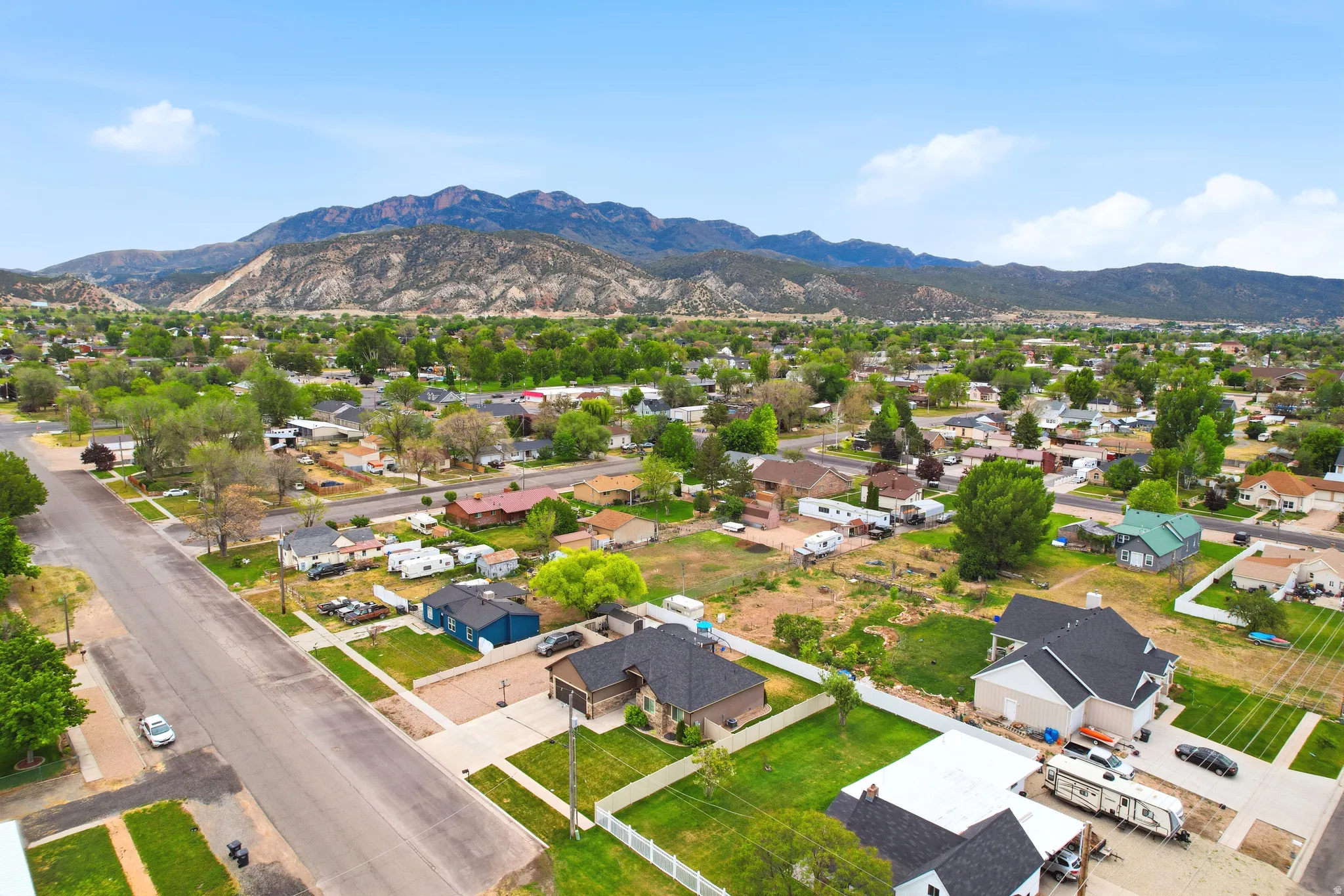 Residential neighborhood with established homes and mature trees against a mountain backdrop