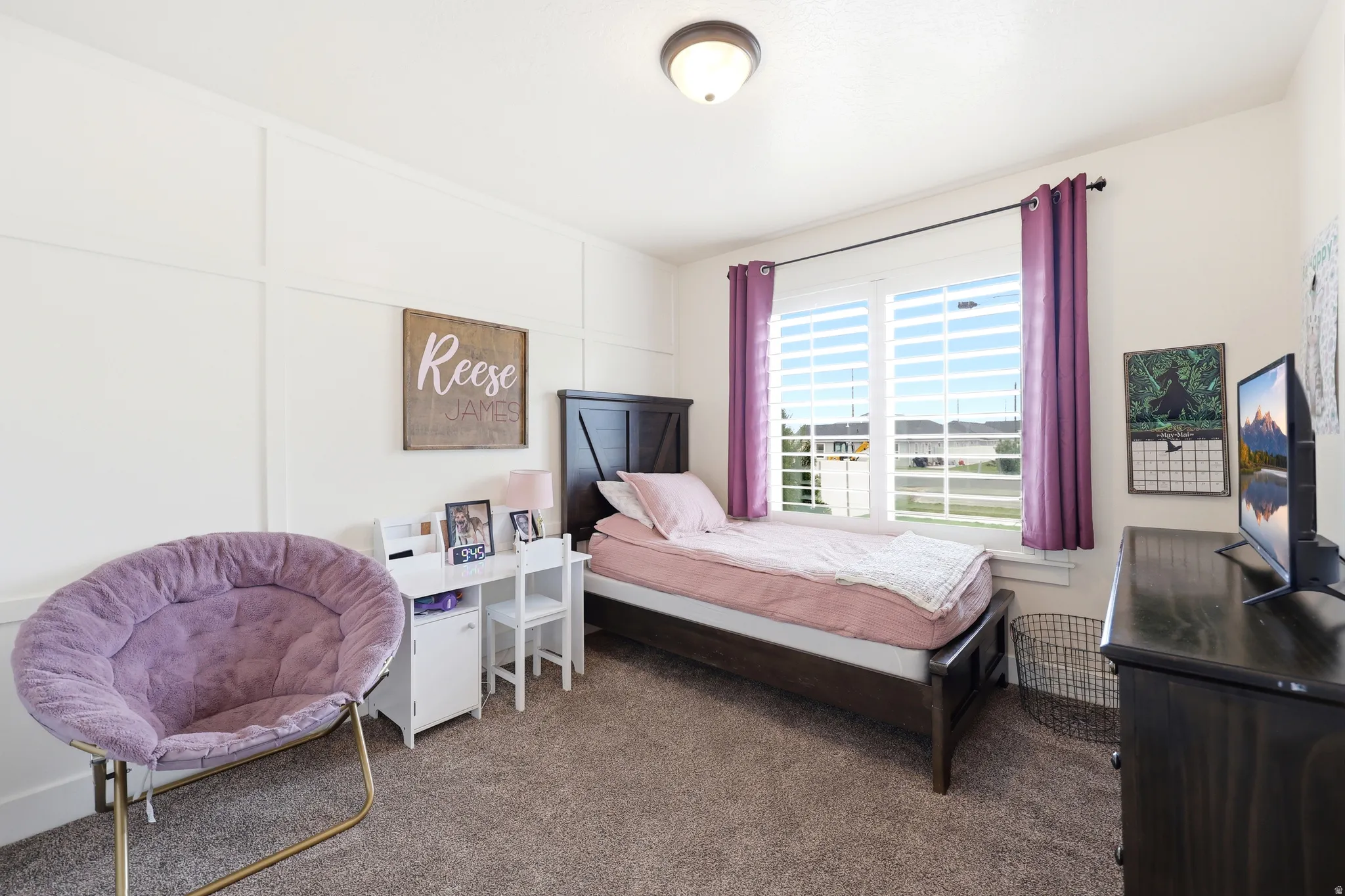 Interior room featuring textured carpet flooring, a large window with white blinds, and board and batten wall detailing