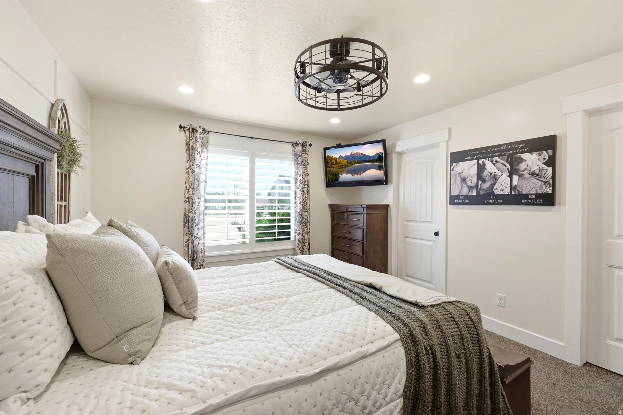Bedroom featuring a dark wood headboard, integrated ceiling fan with lighting, recessed ceiling lights, and window with plantation shutters