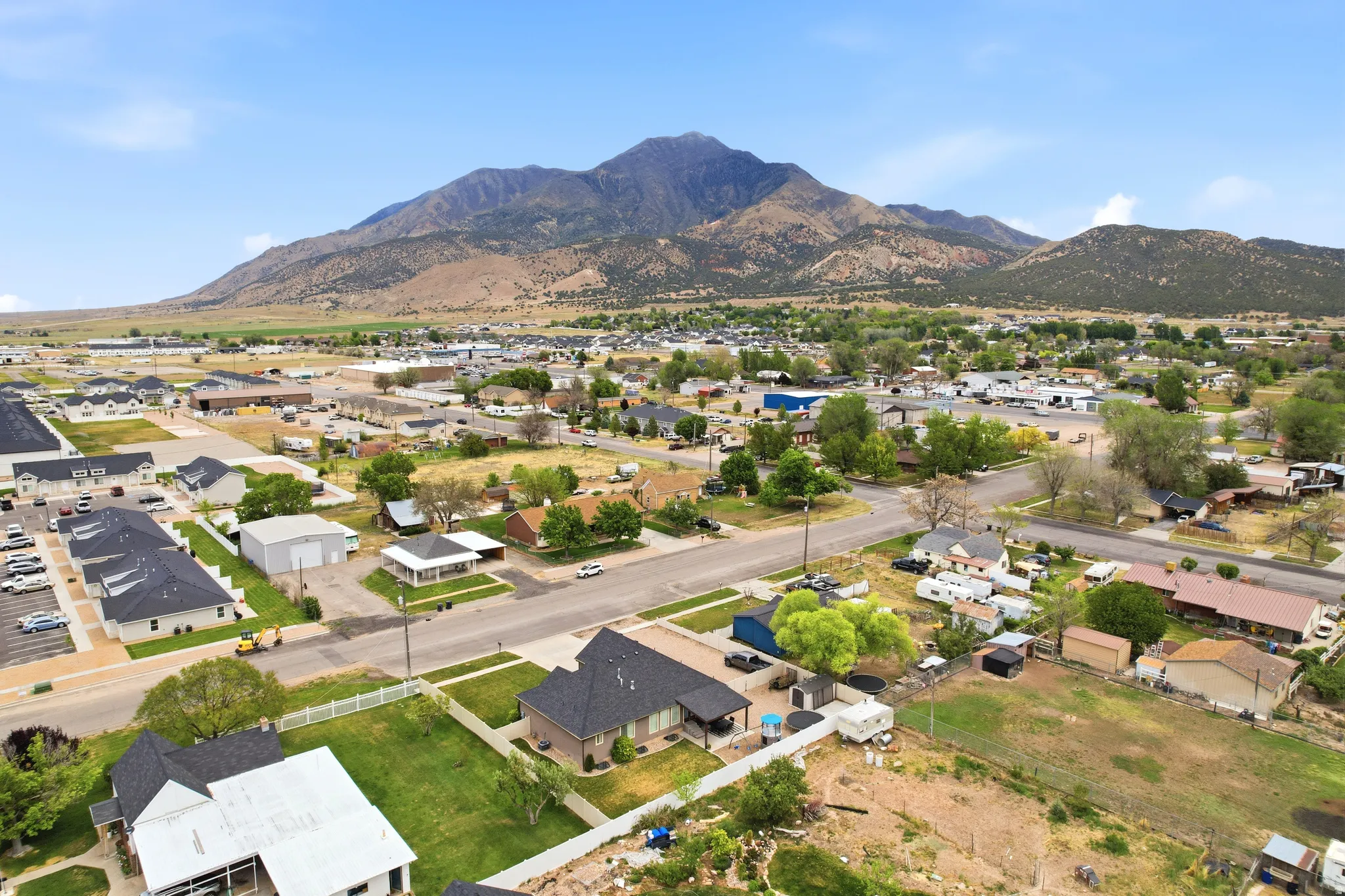Expansive aerial perspective showcasing a residential and commercial area with mountain backdrop