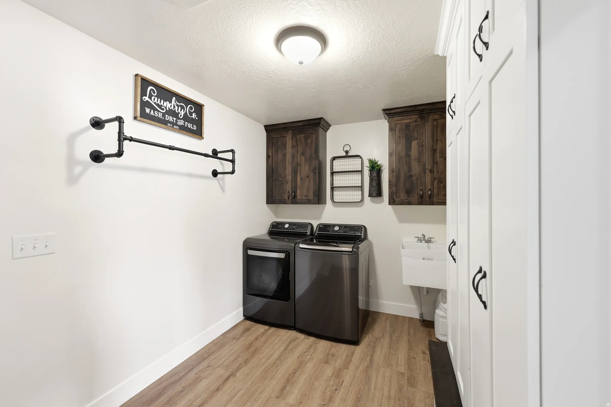 Dedicated laundry area featuring wood-finish flooring