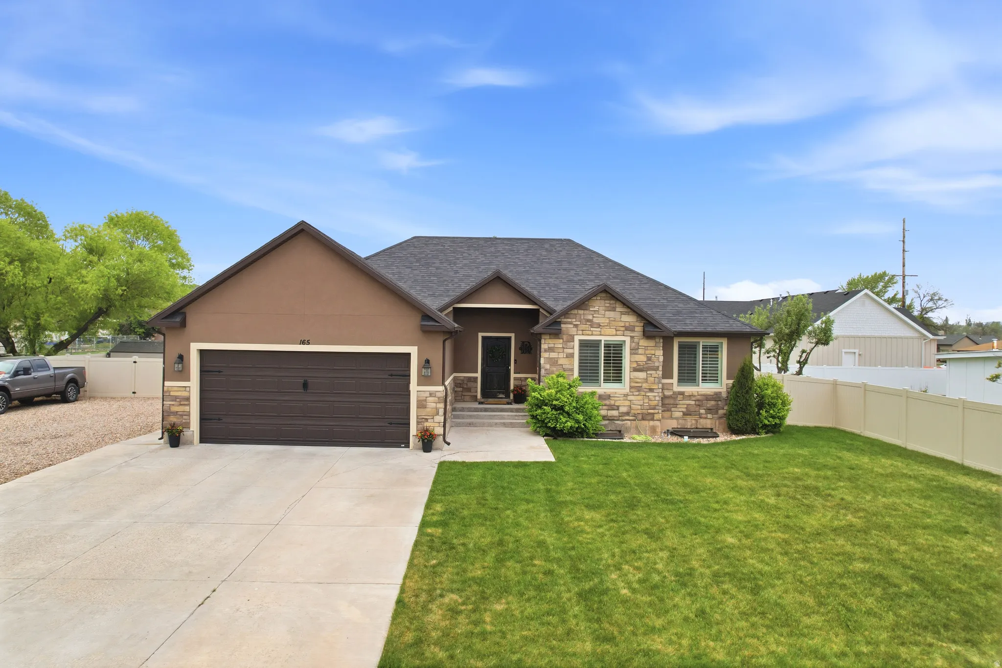 Contemporary ranch-style residence featuring a combination of stucco and stone veneer siding