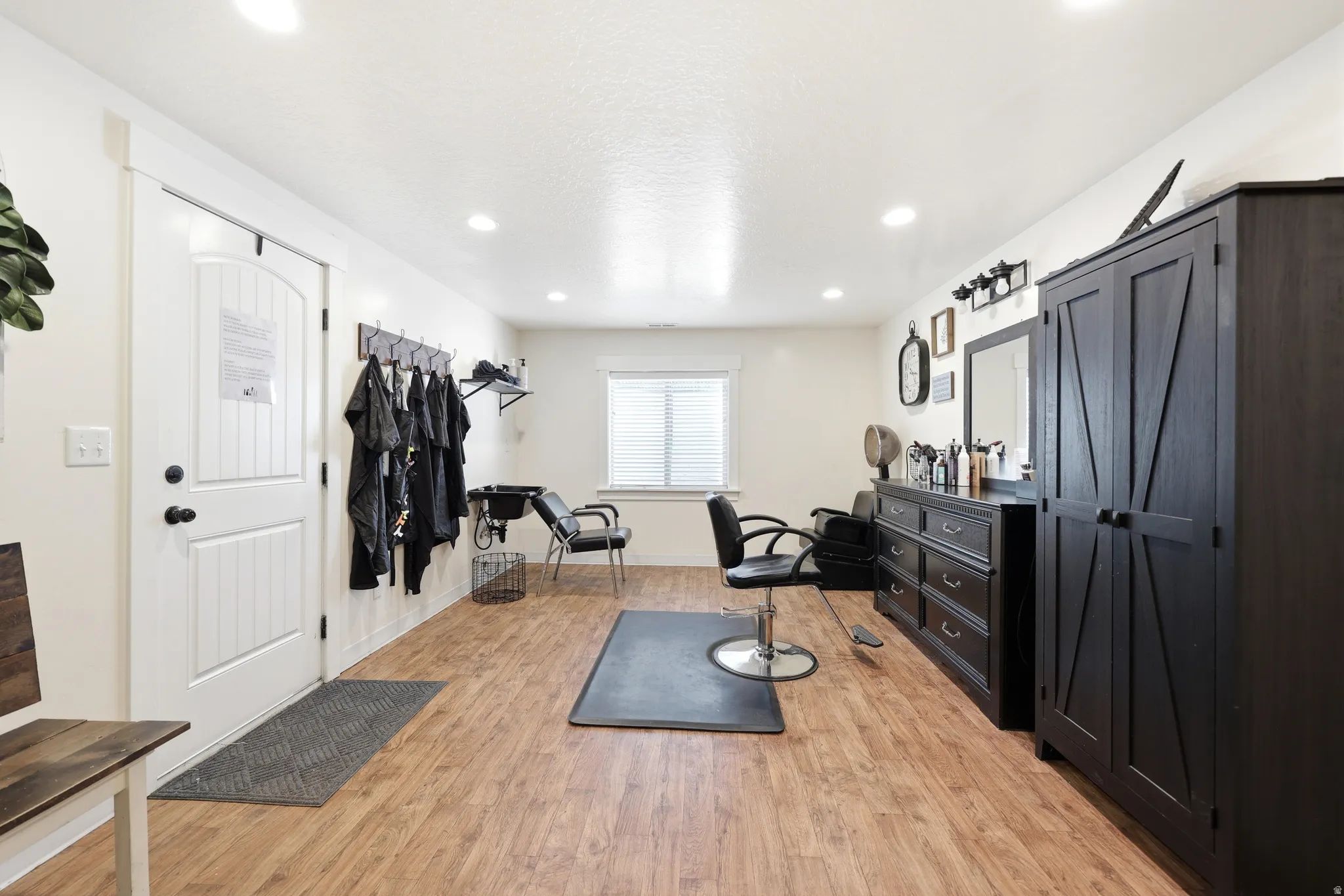 Spacious room featuring wood-finish flooring and recessed lighting