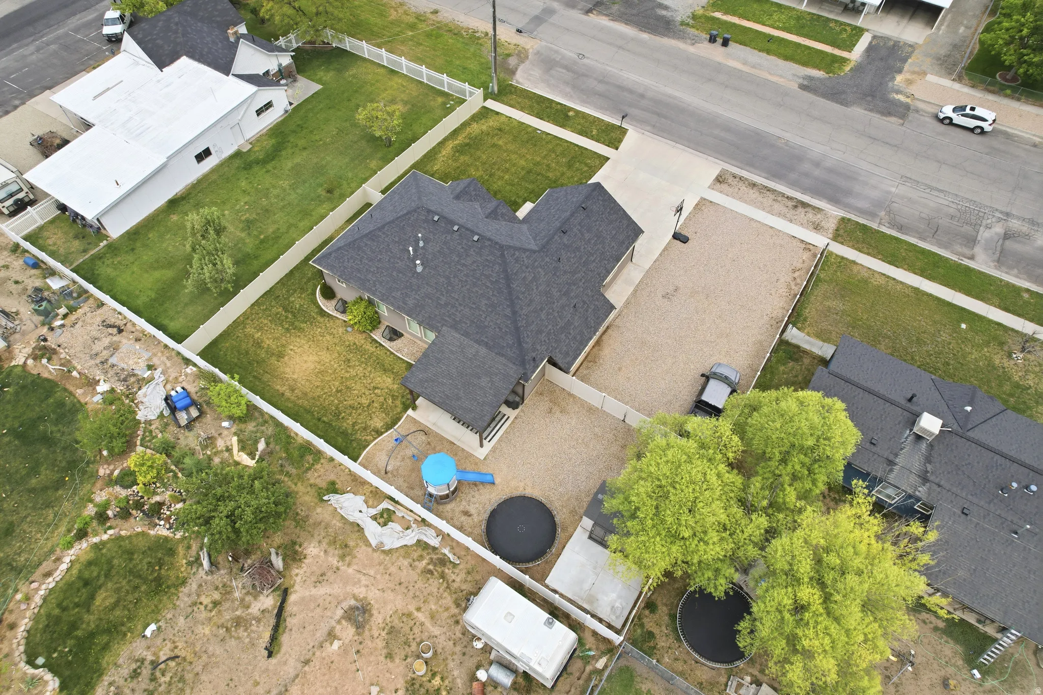 Property featuring a dark shingle roof, light-colored siding, and a paved driveway