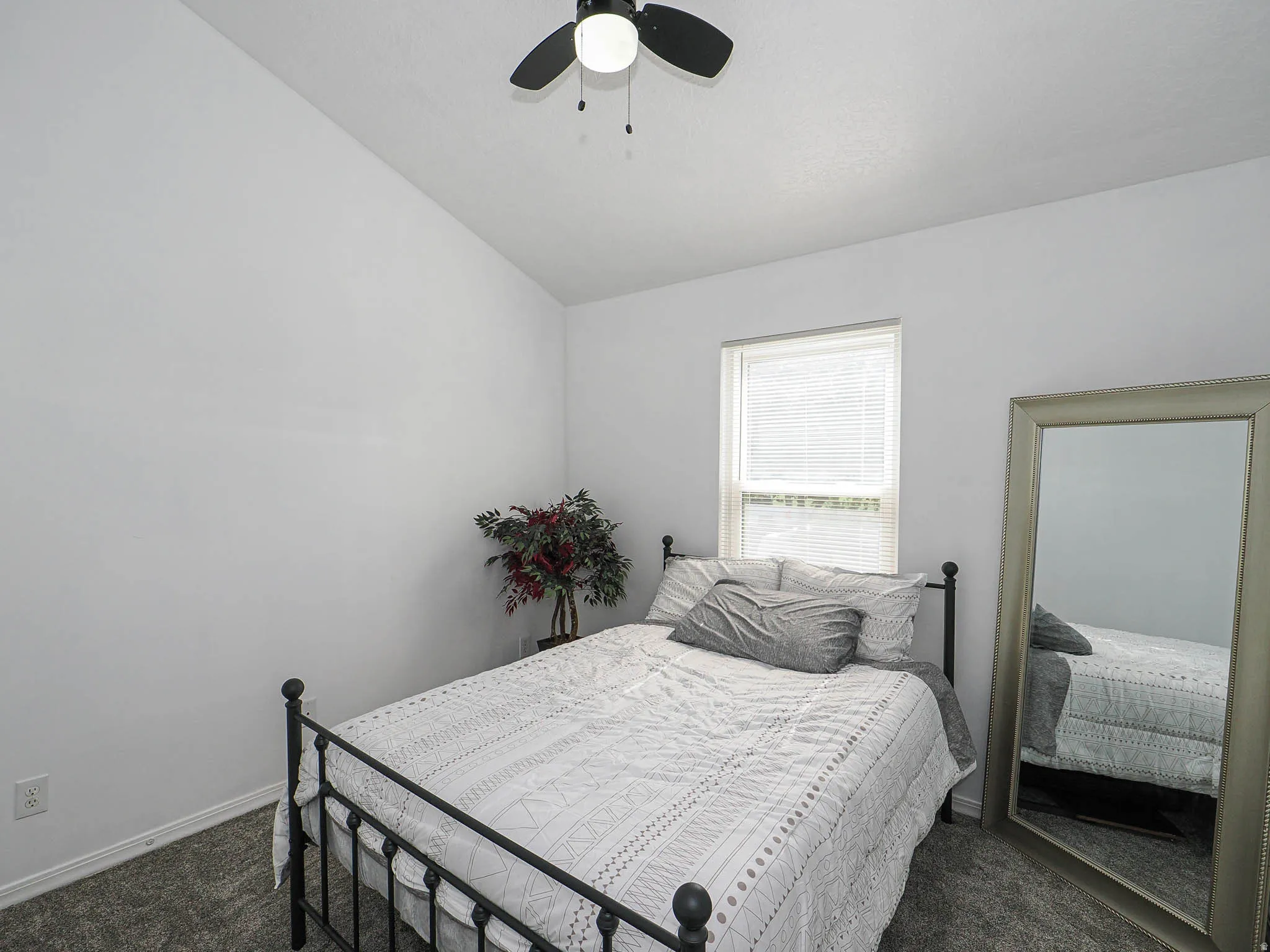 Bedroom featuring vaulted ceilings, a ceiling fan, a window with blinds, and gray carpeting