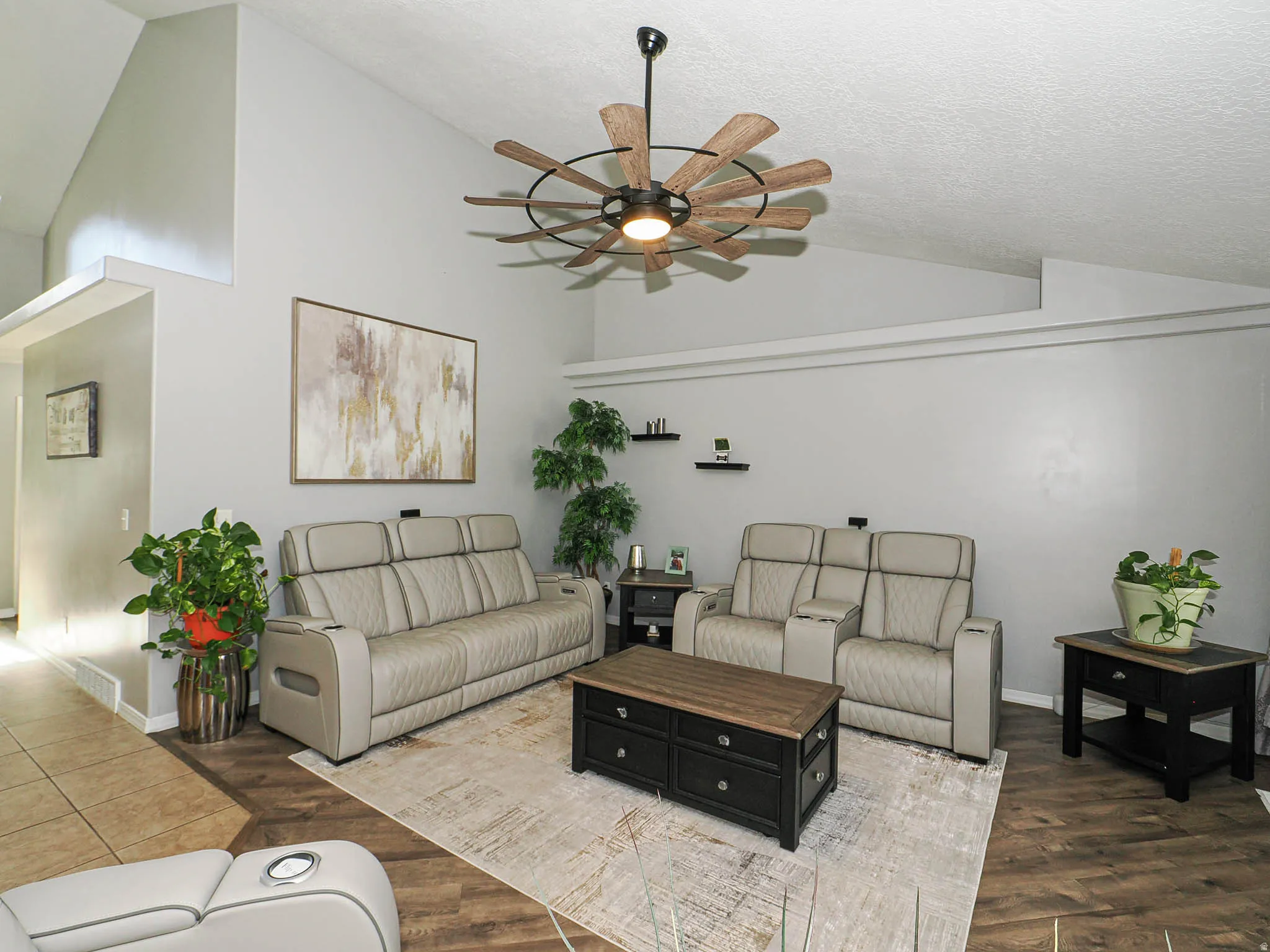 Vaulted ceilings featuring a multi-blade ceiling fan with integrated lighting