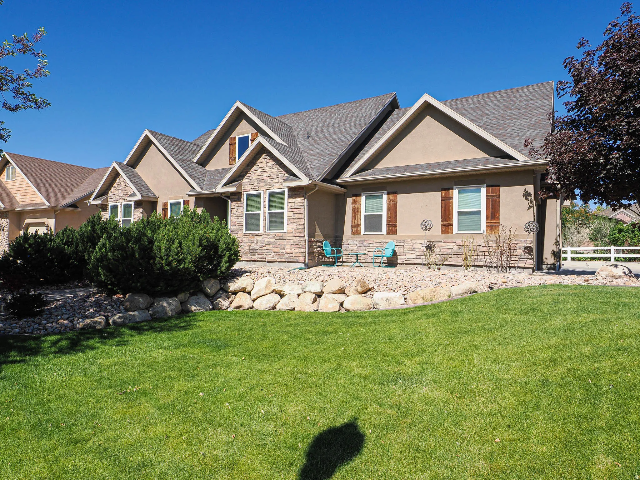 Exterior featuring earth-toned stucco and stacked stone accents