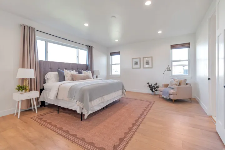 Spacious room featuring light wood-finish flooring and ample natural light from multiple windows
