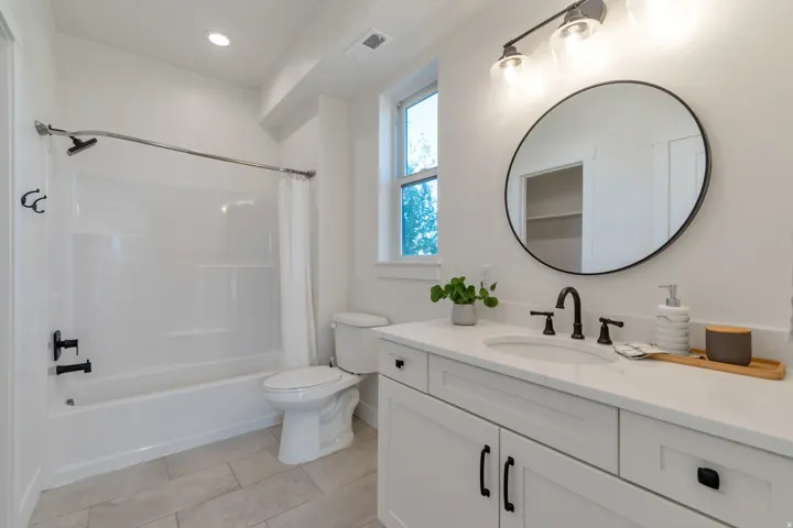 Bathroom featuring a white vanity with a white countertop, undermount sink, and matte black faucet