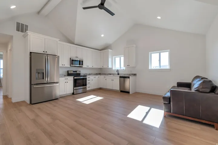 Open-concept living space featuring a vaulted ceiling and wood-finish flooring