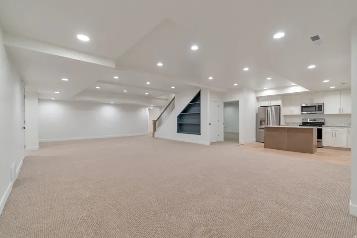 Expansive open-concept living area featuring plush carpeting and recessed lighting