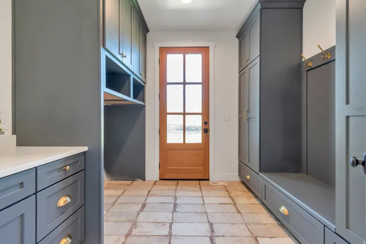 Mudroom entry with a wood-paneled door featuring glass inserts