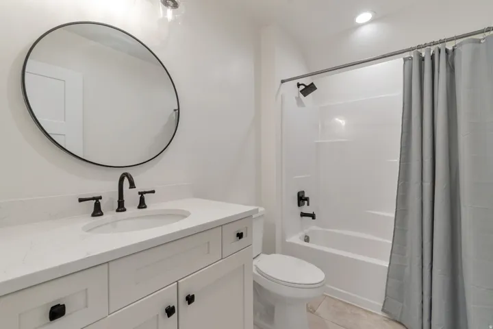 Bathroom featuring a white vanity with a white countertop, an undermount sink, and matte black fixtures