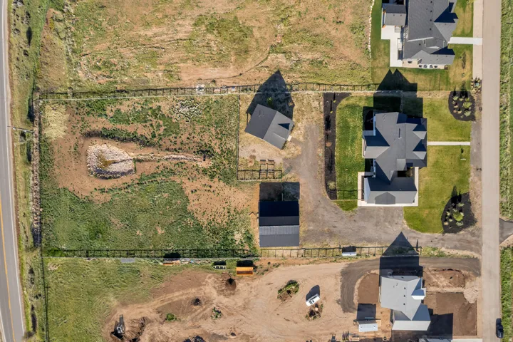 Expansive property featuring a developed road frontage, multiple outbuildings, and a large, fenced parcel