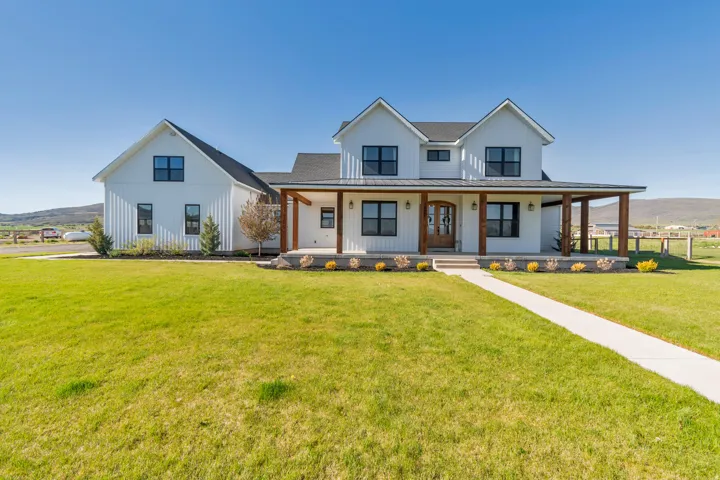 Modern farmhouse exterior featuring white vertical siding and black-framed windows