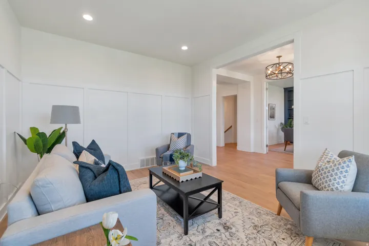 Living area featuring wainscoting, recessed lighting, wood-finish flooring, and a wide entryway