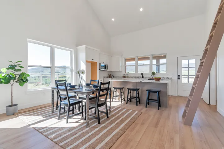 Open-concept kitchen and dining area featuring vaulted ceilings and recessed lighting