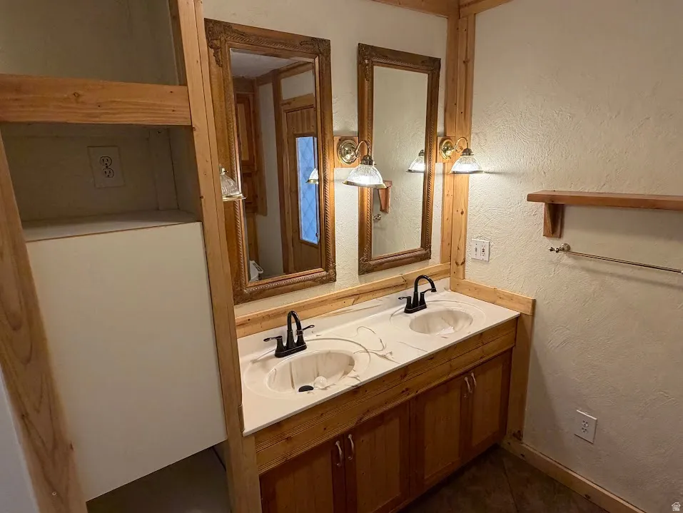 Dual vanity with integrated sinks, wood-finish cabinetry, and framed mirrors