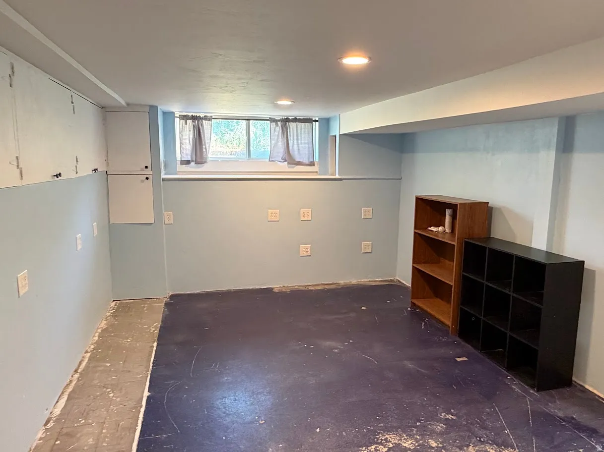Windowed room with built-in cabinetry, recessed lighting, and light blue wall tones