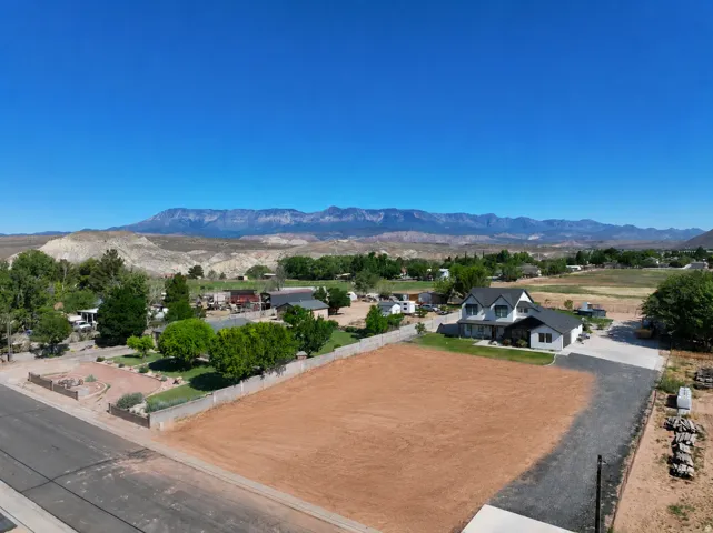 Expansive lot featuring a clear, level building area, a paved driveway, and mature landscaping