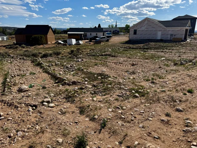 Expansive land parcel featuring existing ground cover and scattered natural stones