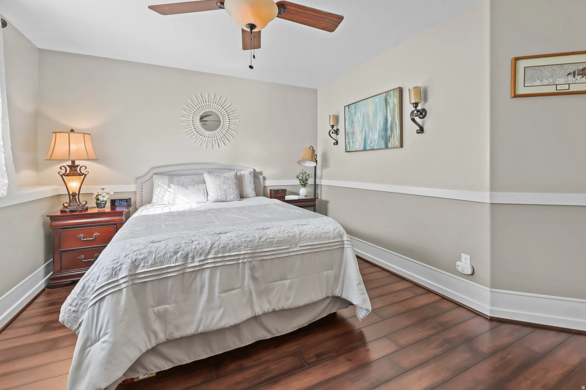 Spacious room featuring wood-finish flooring, a ceiling fan, and crown molding