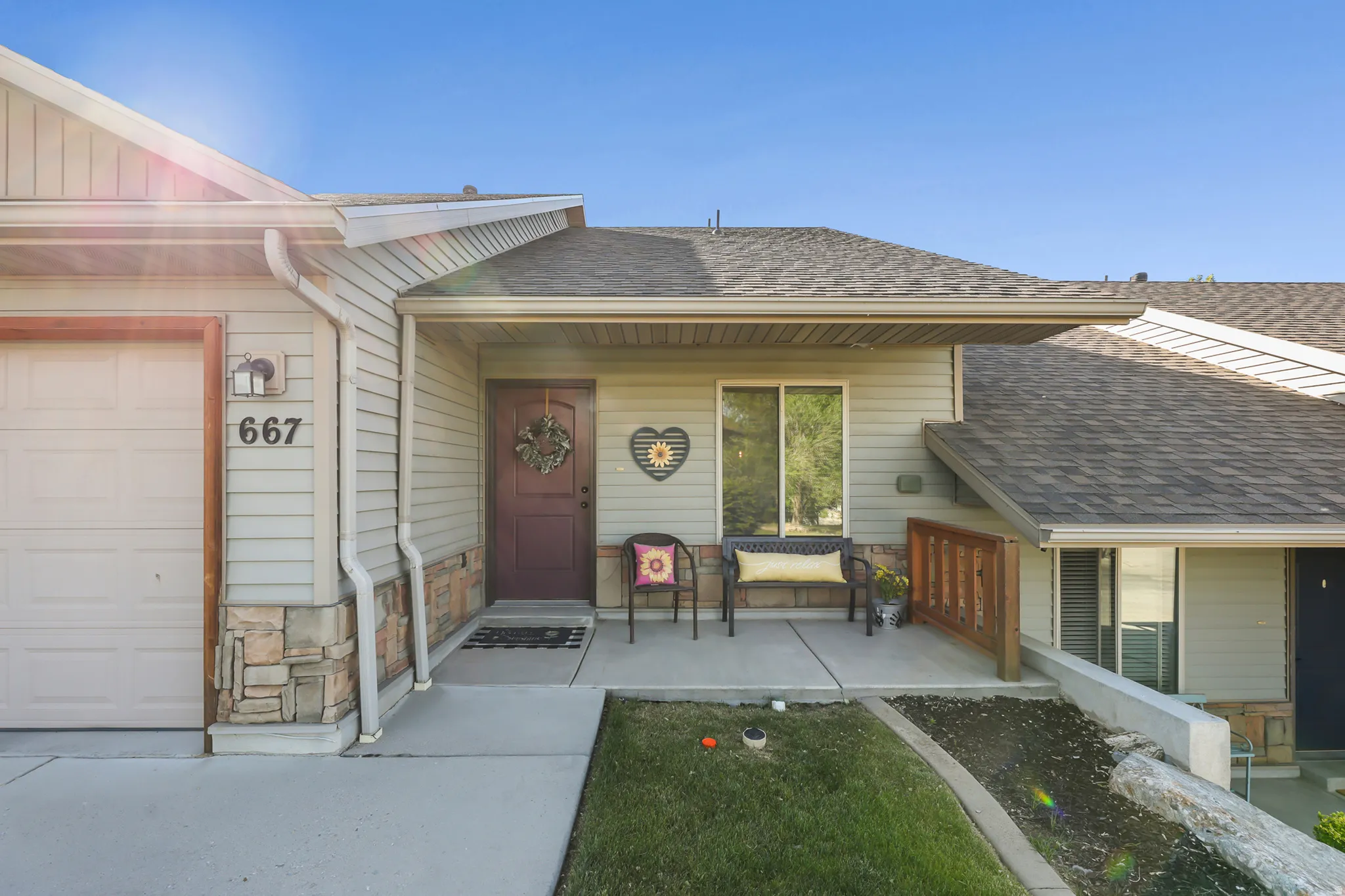 Inviting entry featuring a covered porch, durable siding, and stone veneer accents