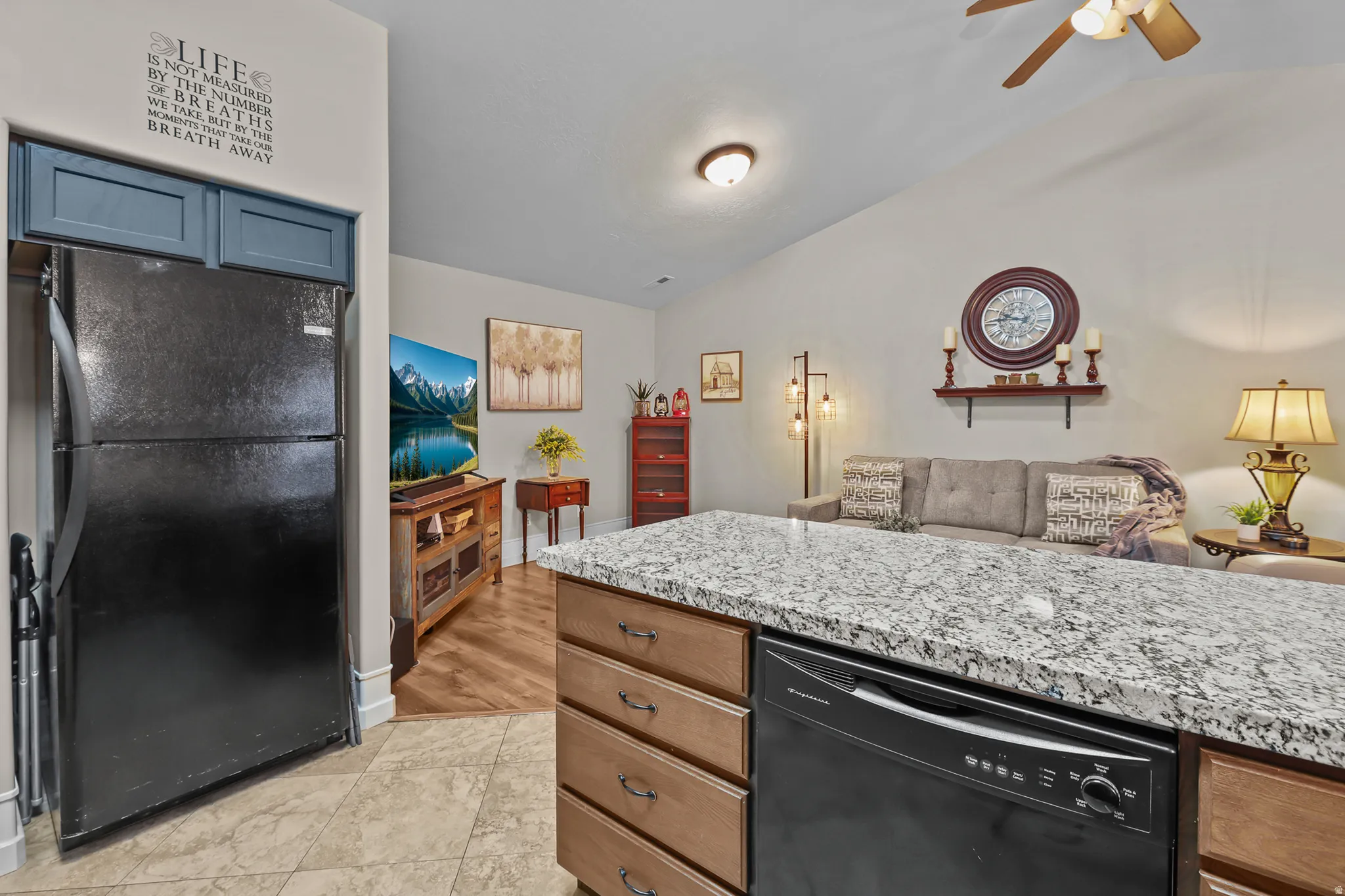 Kitchen island with granite-style countertop, integrated dishwasher, and wood-finish cabinetry