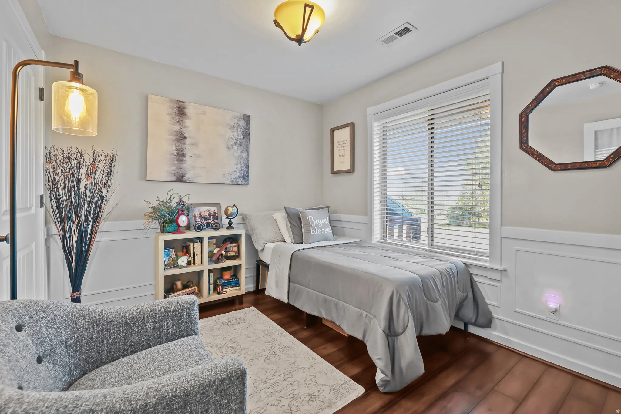 Bright interior space featuring wood-finish flooring, wainscoting, and a window with blinds