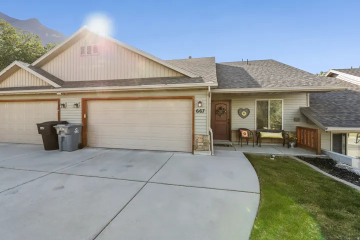 Exterior featuring horizontal siding, a covered entry, and a two-car garage with individual doors
