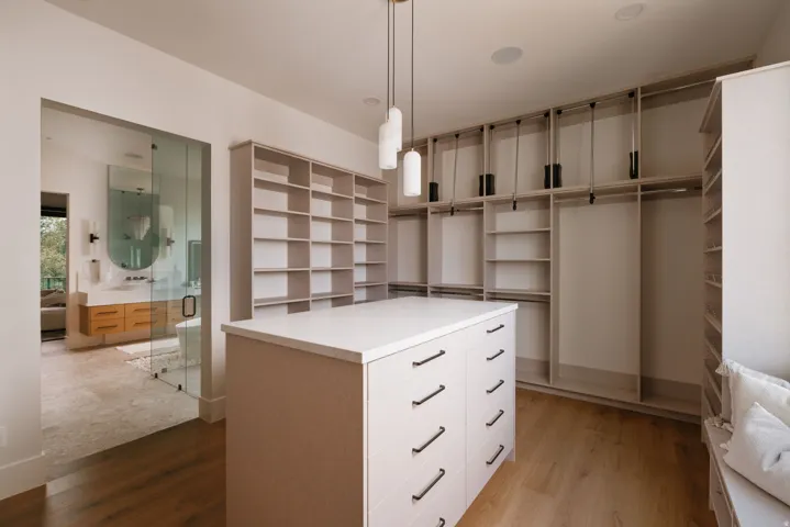 Custom closet system featuring a central island with drawer storage, extensive shelving, and multiple hanging rods