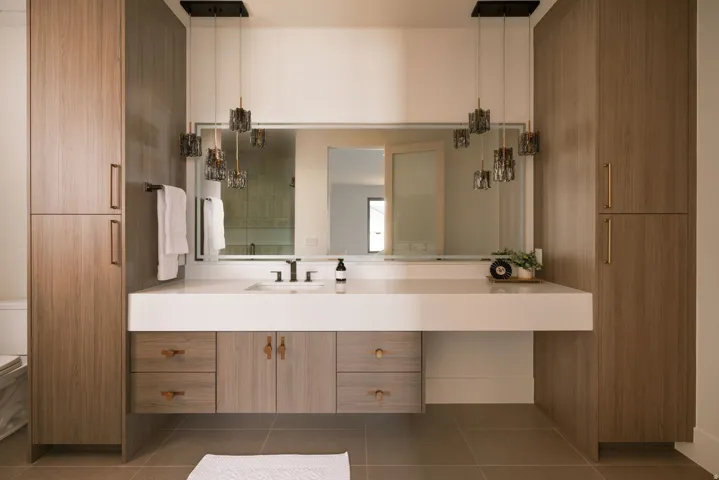 Floating vanity with integrated sink, white countertop, and wood-finish cabinetry