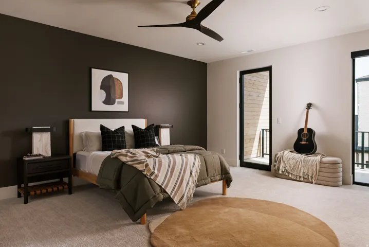 Spacious room featuring light-toned carpet, a contrasting dark accent wall, and recessed lighting
