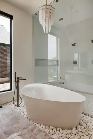 Freestanding soaking tub set in decorative river rock