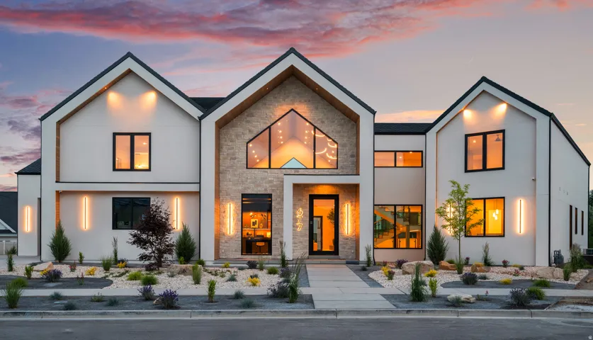 Modern architectural exterior featuring white stucco, stone veneer, and black-framed windows