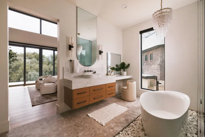 Freestanding soaking tub with a surrounding white pebble floor detail
