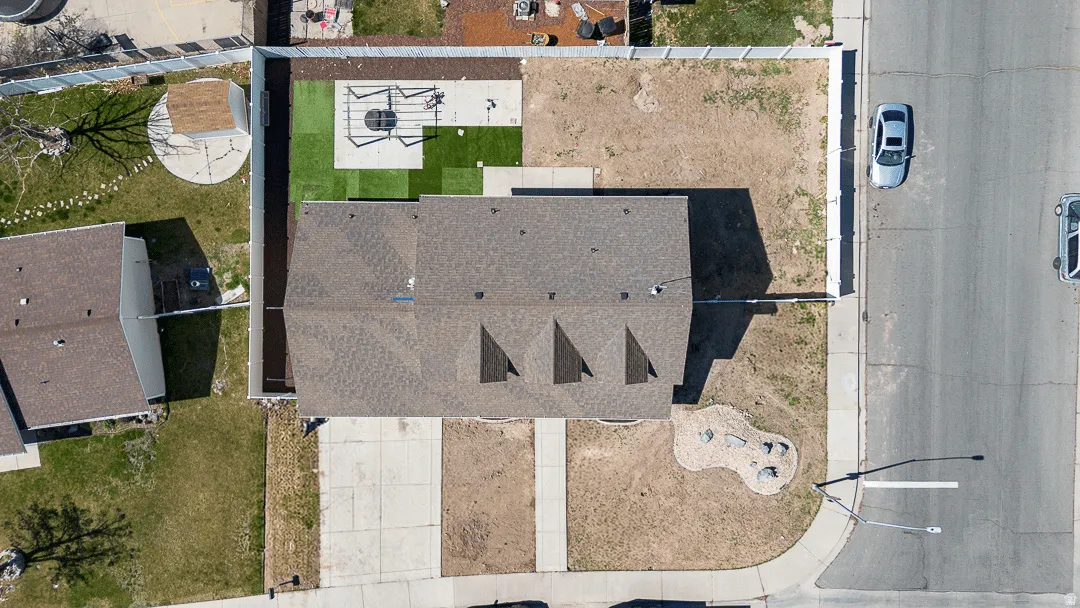 Aerial perspective showcasing the property's roofline, concrete driveway, and front yard landscaping