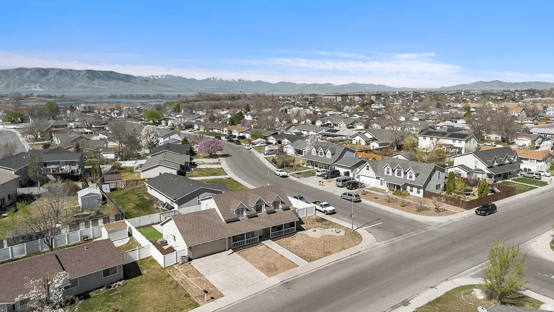 Suburban neighborhood featuring varied residential architecture, mature trees, and paved roads