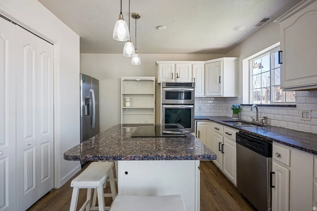 Kitchen featuring a central island with an integrated cooktop and overhead pendant lighting