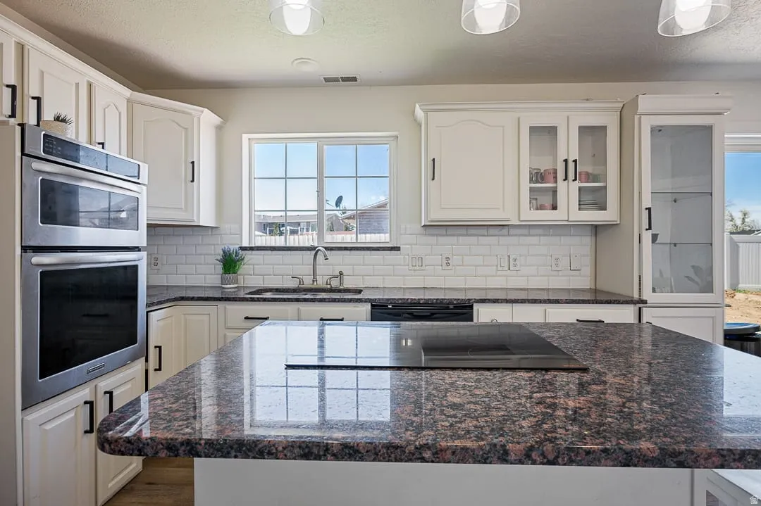 Kitchen featuring a large island with an integrated cooktop and granite countertops