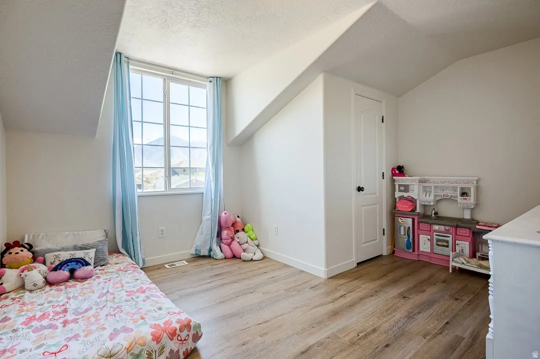 Room featuring wood-finish flooring and a white paneled door with black hardware