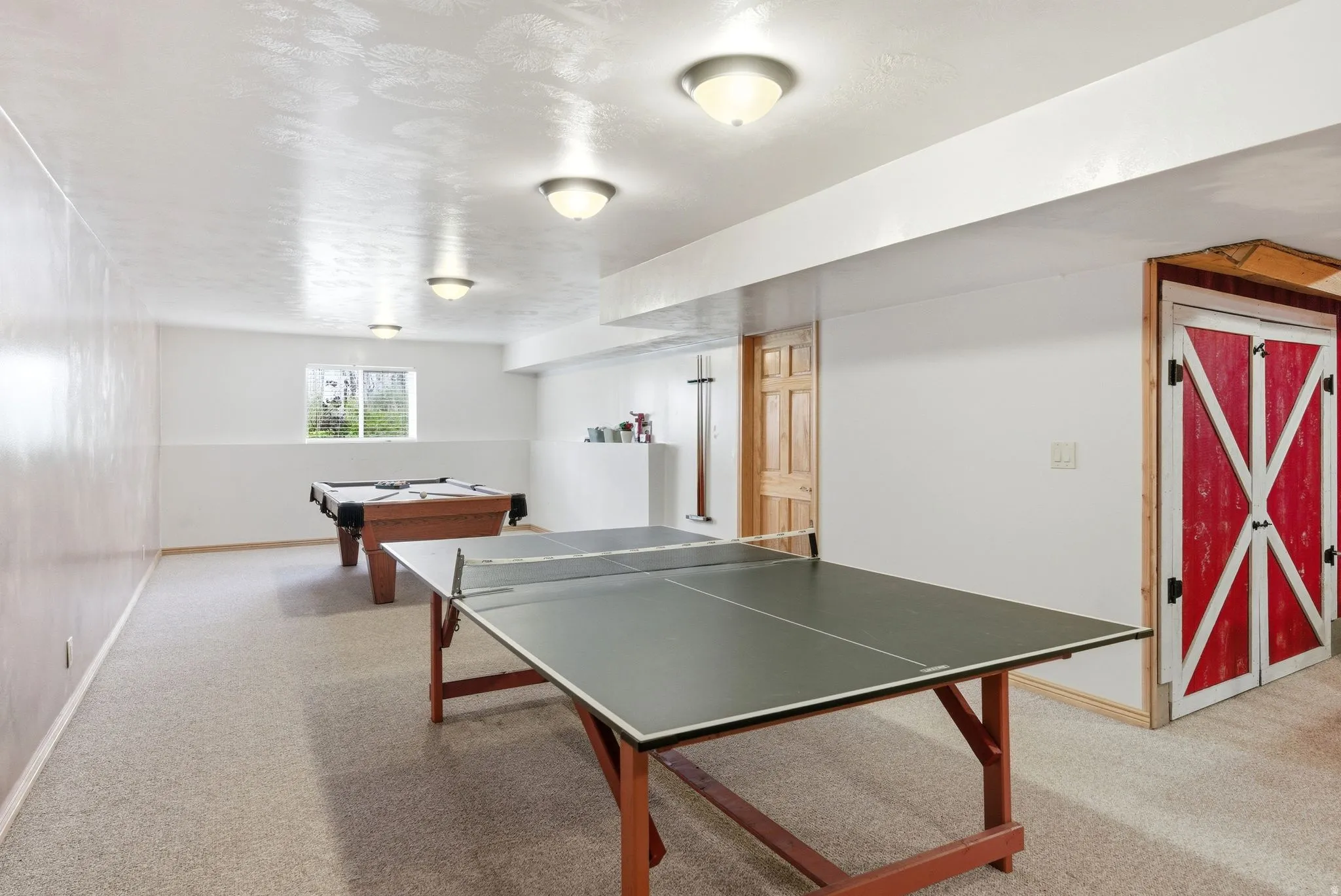 Spacious recreation room featuring neutral carpeting and recessed lighting